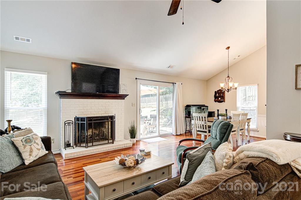 10715 Spruce Mountain Road Charlotte, NC 28214 - Photo 7 of 33 a living room with furniture a flat screen tv and a fireplace
