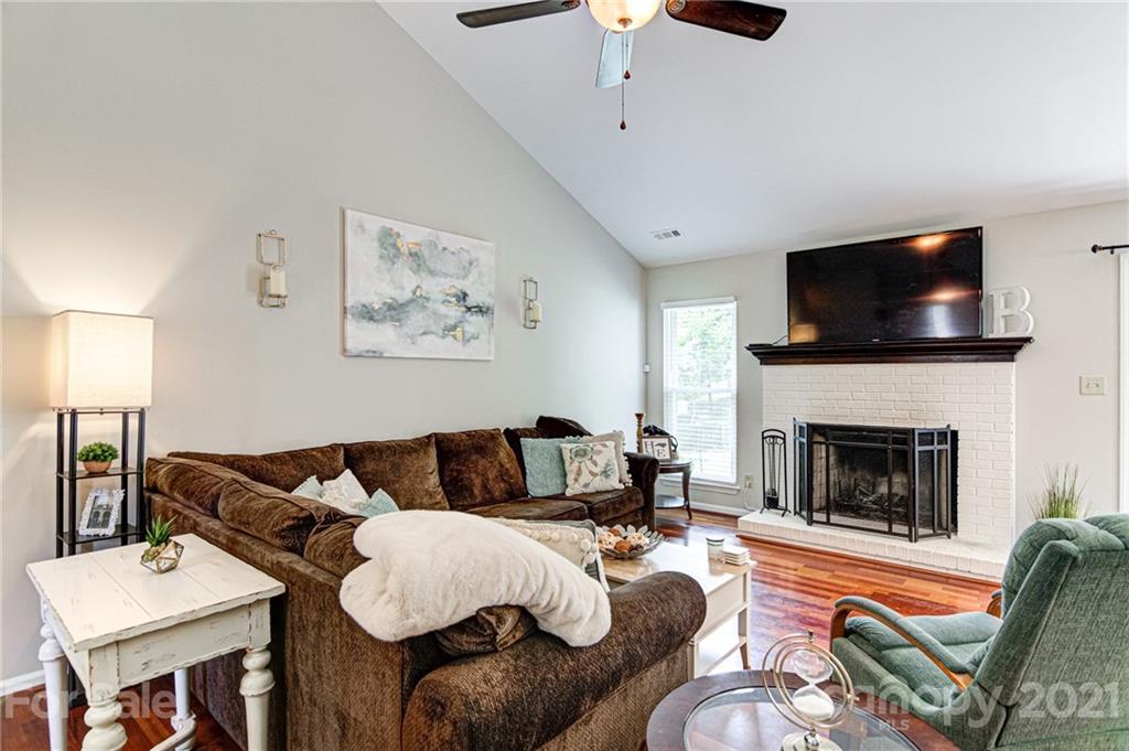 10715 Spruce Mountain Road Charlotte, NC 28214 - Photo 8 of 33 a living room with furniture a flat screen tv and a fireplace