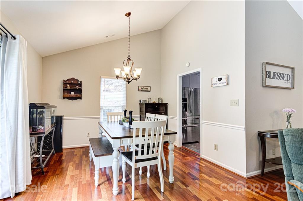 10715 Spruce Mountain Road Charlotte, NC 28214 - Photo 10 of 33 a view of a dining room with furniture a chandelier and wooden floor