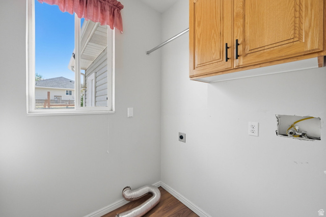 3732 Campbell Road Tooele, UT 84074 - Photo 17 of 69 Laundry area featuring wood-finish flooring, built-in upper cabinetry with black hardware, and an overhead clothes hanging rod
