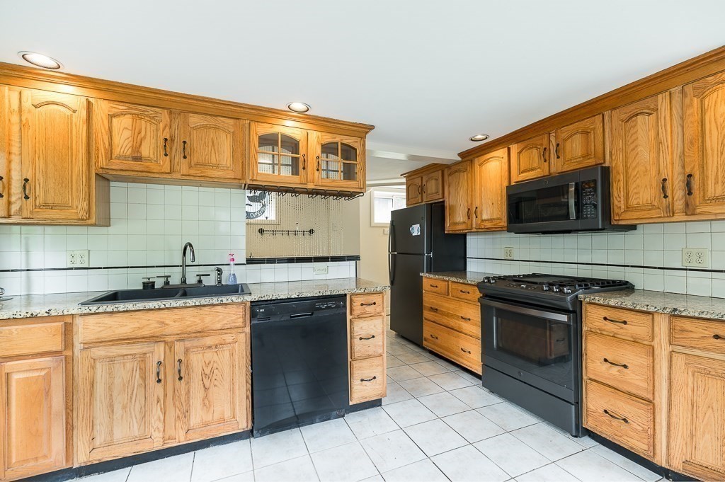 133 Thatcher Road Gloucester, MA 01930 - Photo 11 of 32 a kitchen with stainless steel appliances granite countertop a stove sink and cabinets