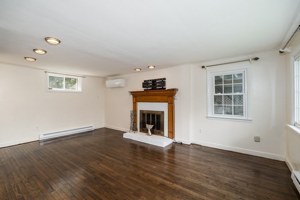 133 Thatcher Road Gloucester, MA 01930 - Photo 8 of 32 a view of an empty room with wooden floor fireplace and a window