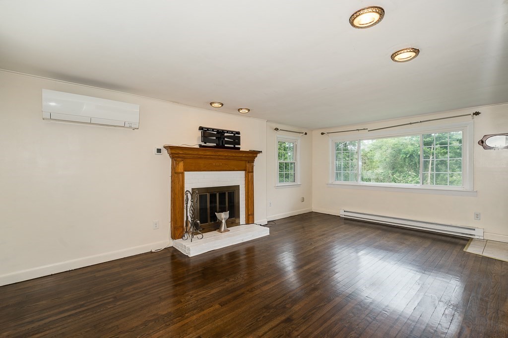 133 Thatcher Road Gloucester, MA 01930 - Photo 9 of 32 an empty room with wooden floor fireplace and windows