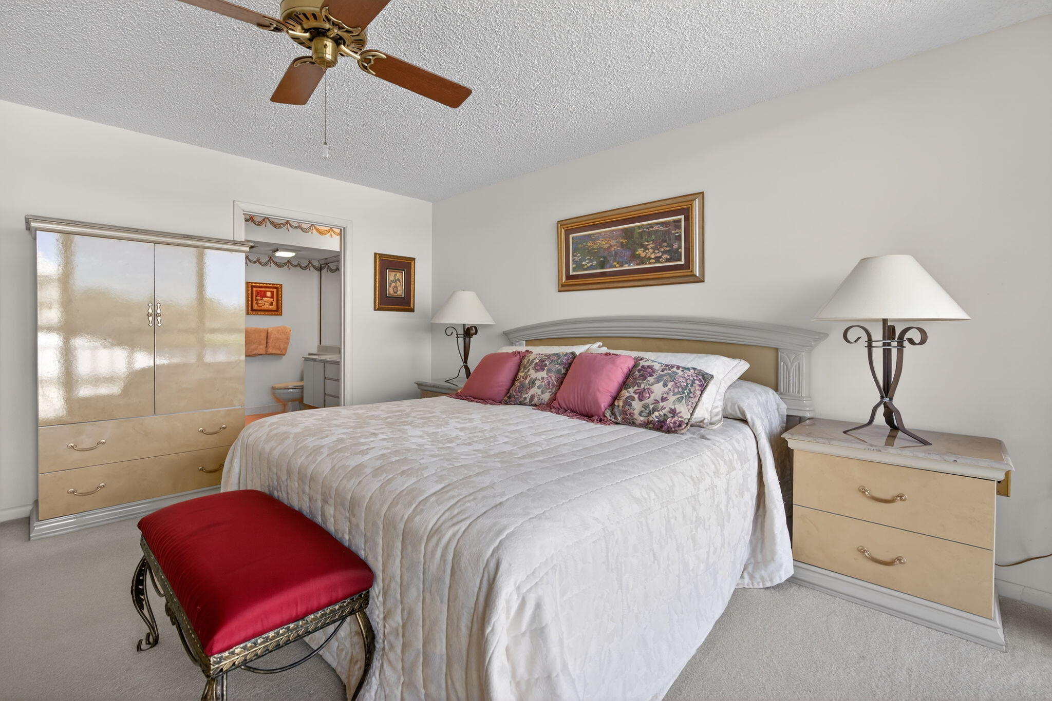2601 Village Boulevard, Unit 303 West Palm Beach, FL 33409 - Photo 12 of 23 a bedroom with a bed and a lamp on dresser