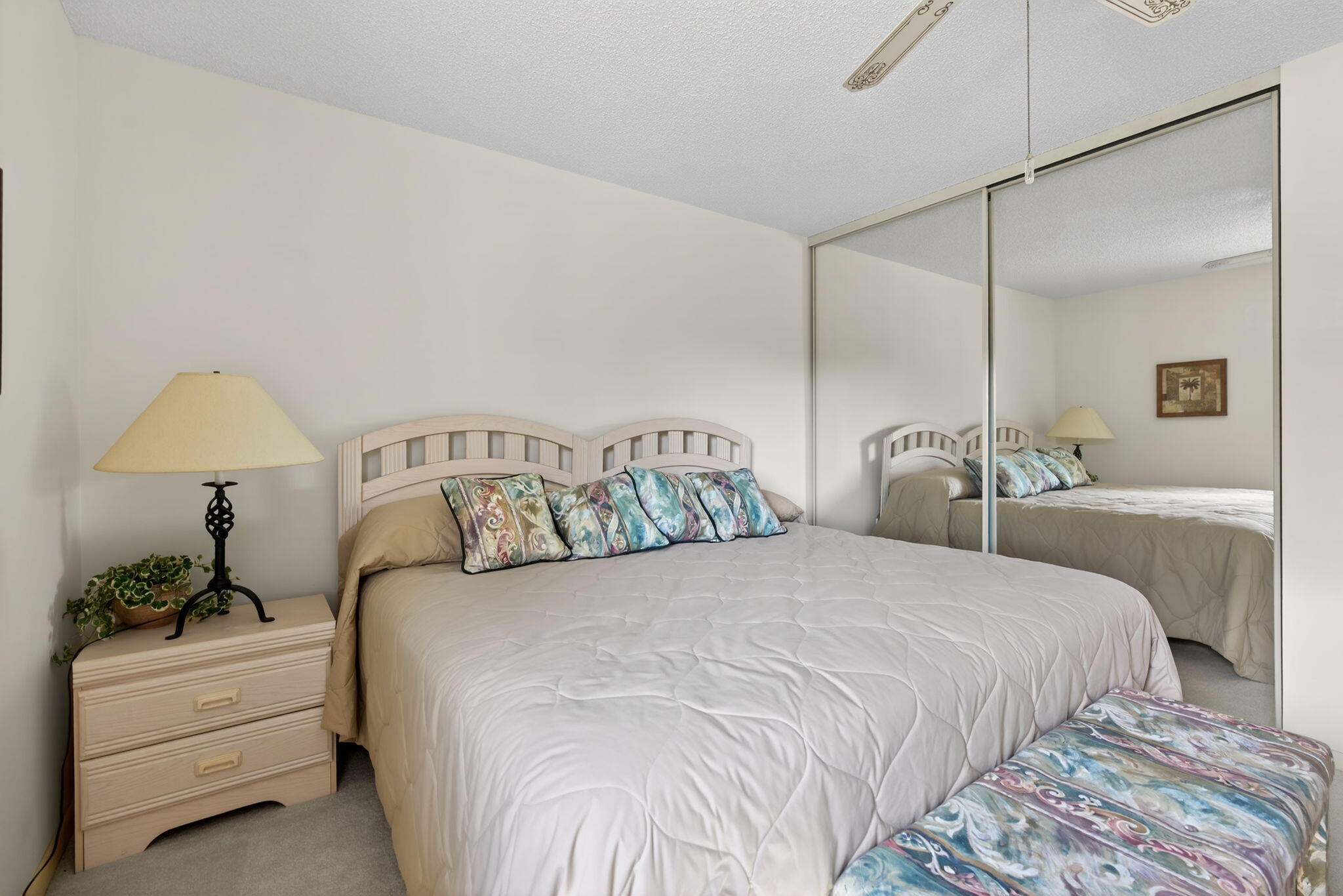 2601 Village Boulevard, Unit 303 West Palm Beach, FL 33409 - Photo 16 of 23 a bedroom with a white bed and a chandelier
