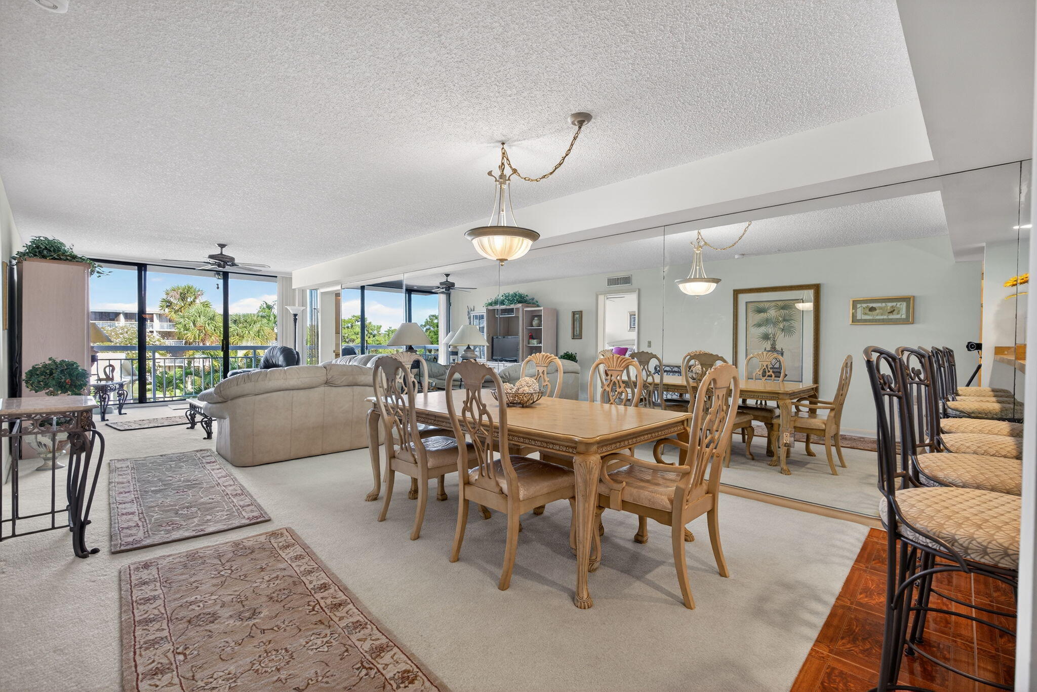 2601 Village Boulevard, Unit 303 West Palm Beach, FL 33409 - Photo 6 of 23 a view of a dining room and livingroom with furniture wooden floor a rug a potted plant and a chandelier