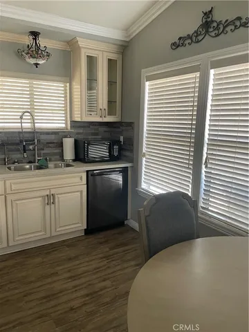 a kitchen with a stove a sink a chair and white cabinets