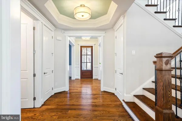 a view of a hallway with wooden floor and staircase