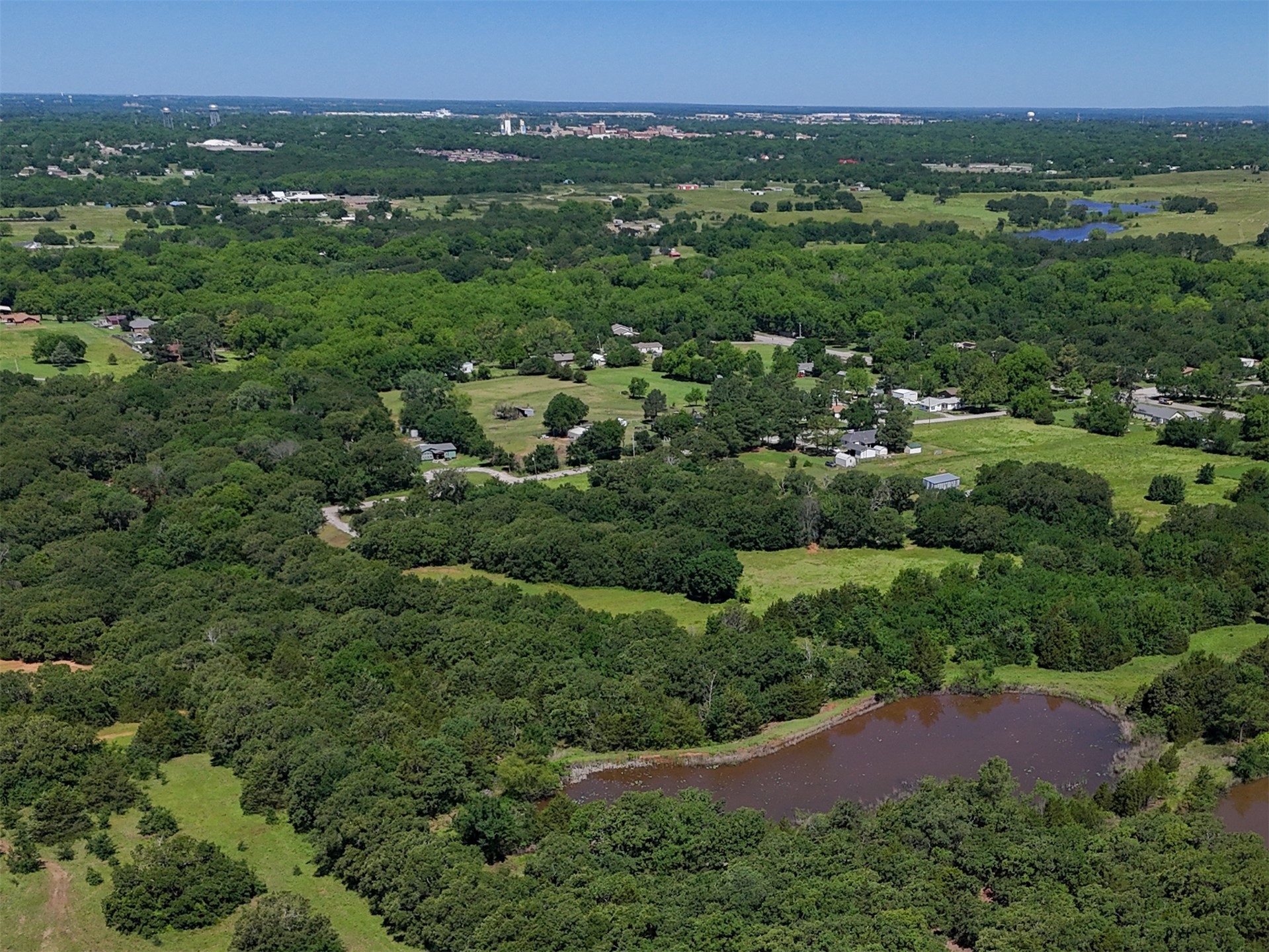 0 Harvey Road Ardmore, OK 73401 - Photo 6 of 10 Expansive landscape featuring mature trees, open green spaces, and a natural pond