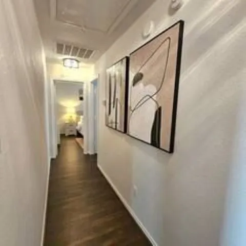 a view of a hallway with wooden floor and staircase