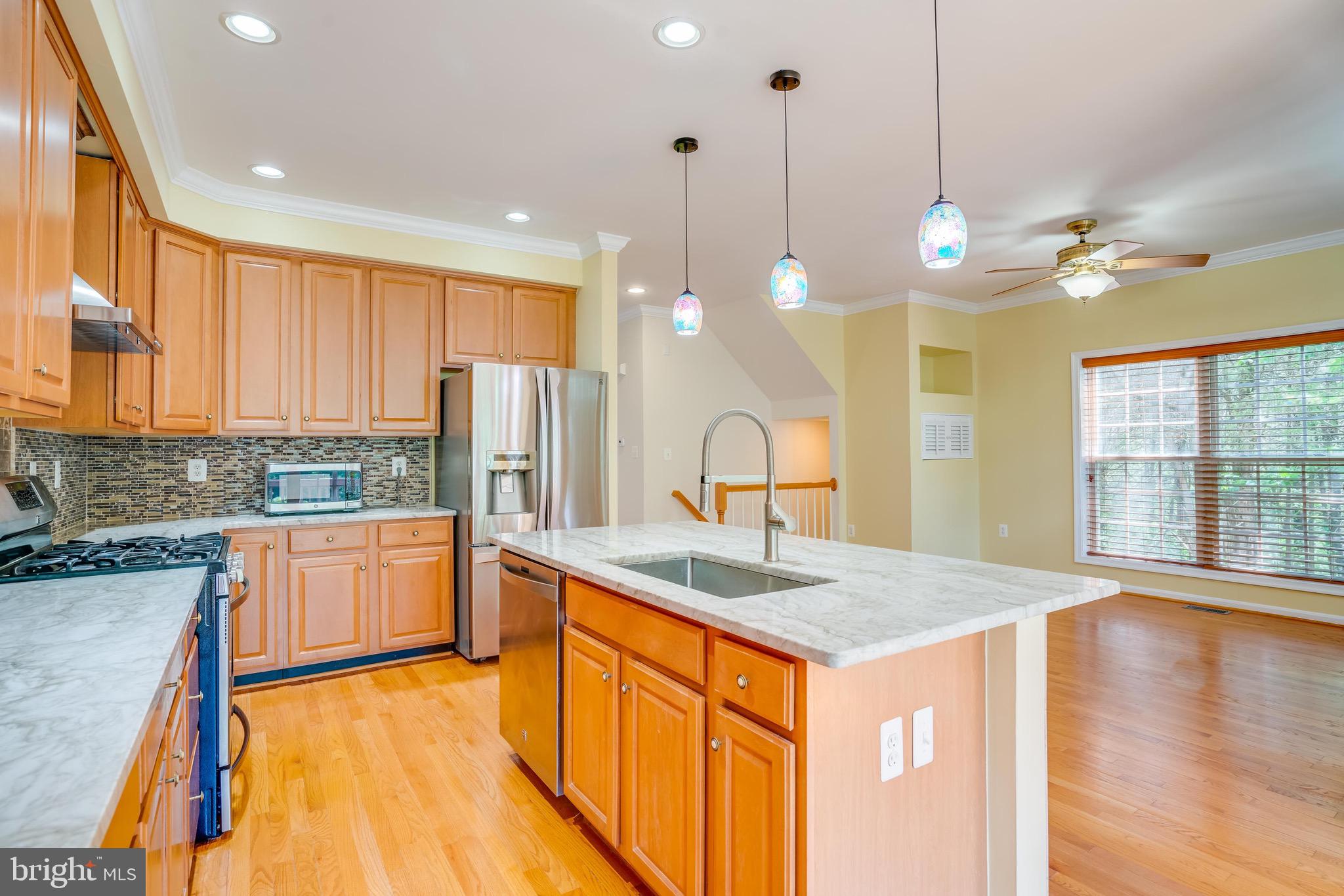 13641 Cedar Run Lane Herndon, VA 20171 - Photo 15 of 56 a kitchen with stainless steel appliances granite countertop a sink a stove a refrigerator and island with wooden floor