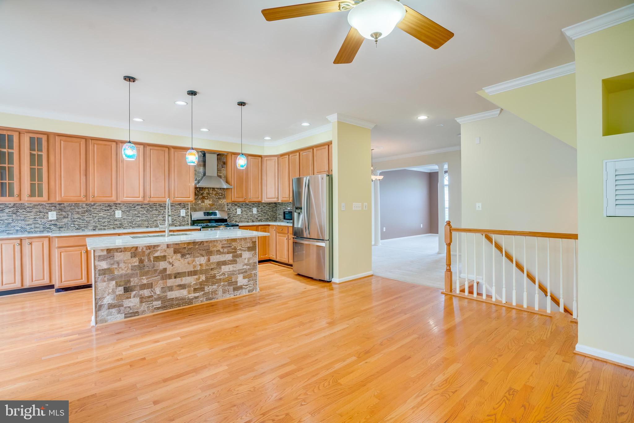 13641 Cedar Run Lane Herndon, VA 20171 - Photo 17 of 56 a large kitchen with stainless steel appliances kitchen island granite countertop a stove a sink a refrigerator and white cabinets with wooden floor