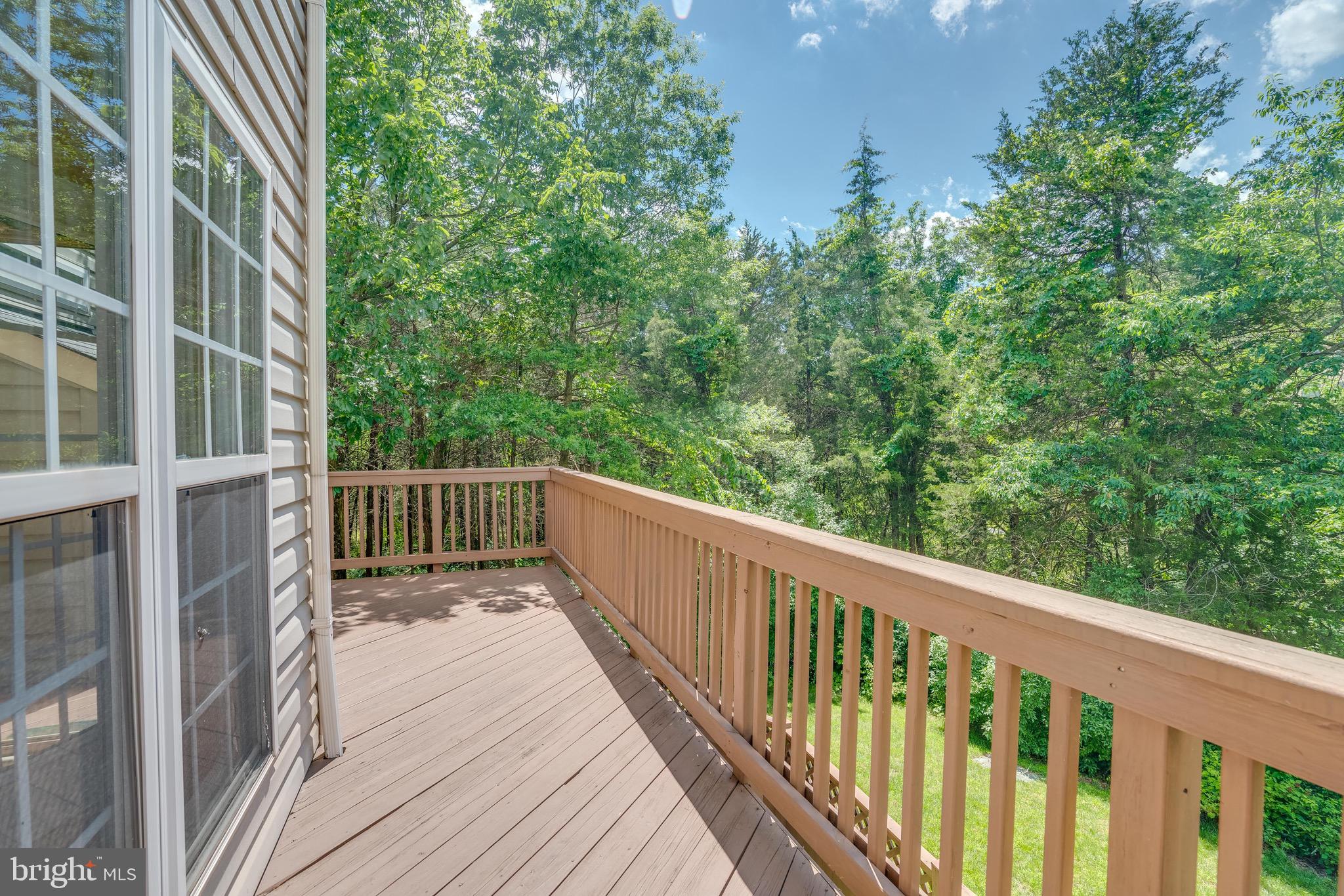 13641 Cedar Run Lane Herndon, VA 20171 - Photo 21 of 56 a balcony with wooden floor and trees in front of it