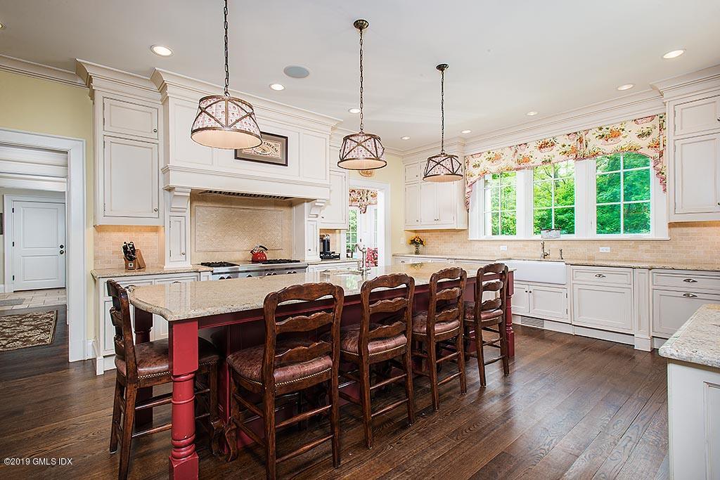 16 Doubling Road Greenwich, CT 06830 - Photo 16 of 45 a kitchen with stainless steel appliances kitchen island a large island in the center and wooden floors