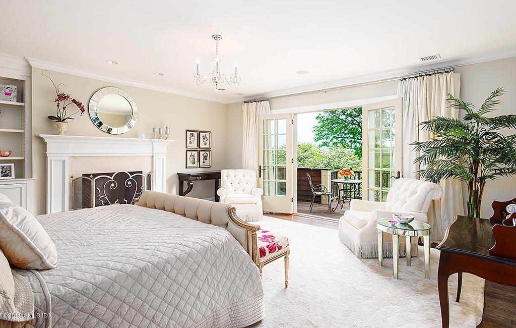 16 Doubling Road Greenwich, CT 06830 - Photo 25 of 45 a bedroom with a large bed and a large window with the garden view