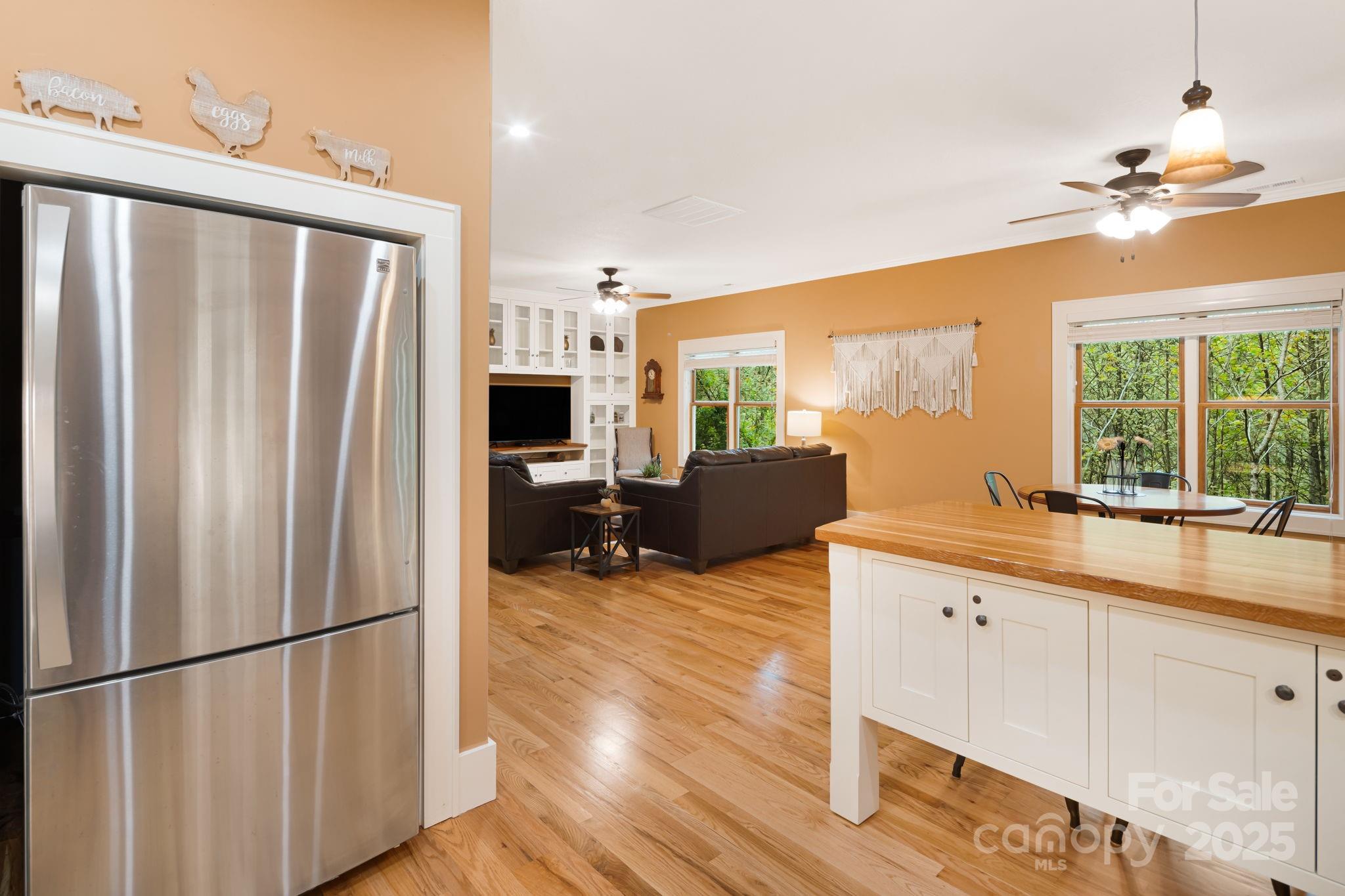 79 Slumber Lane Sylva, NC 28779 - Photo 14 of 29 a kitchen with stainless steel appliances granite countertop a refrigerator a sink dishwasher a dining table and chairs with wooden floor