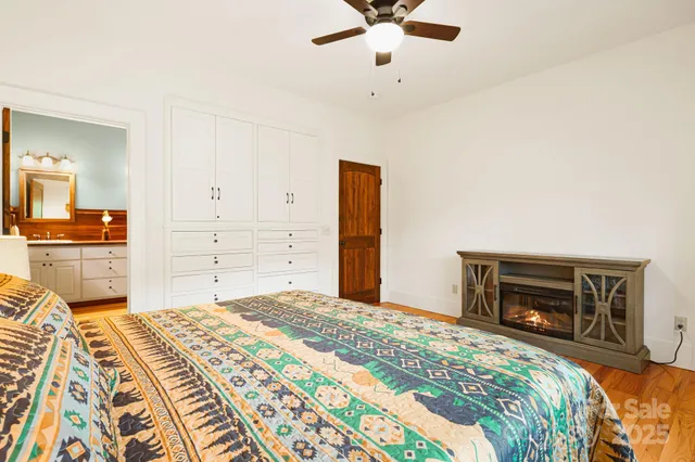 a bedroom with a large bed and a fireplace