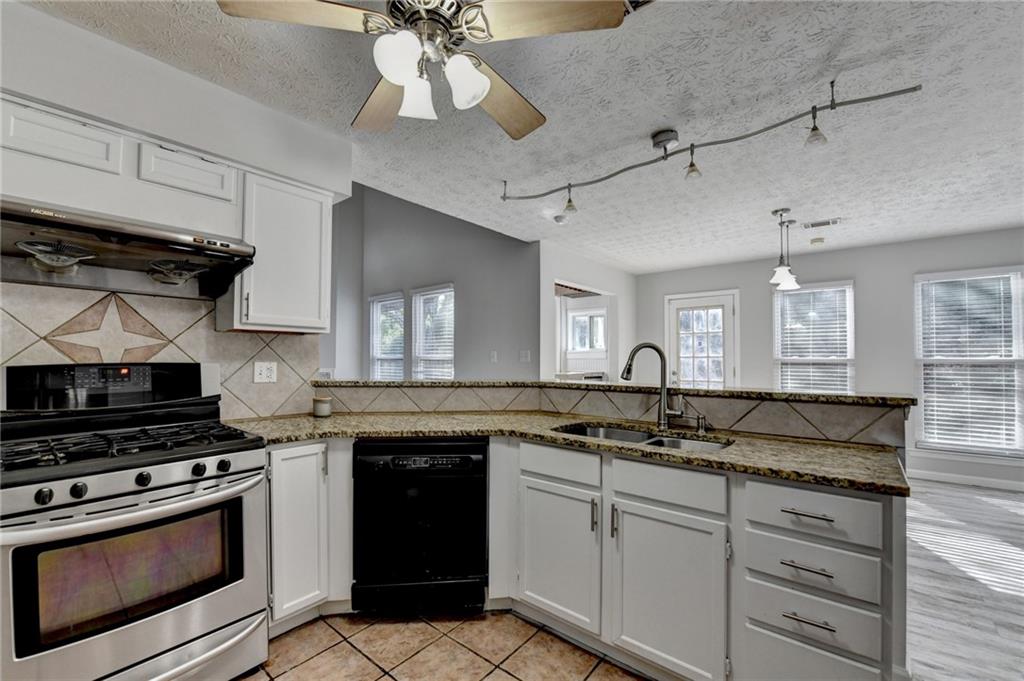 1112 Ashbury Drive Decatur, GA 30030 - Photo 29 of 64 a kitchen with granite countertop a sink cabinets and stainless steel appliances