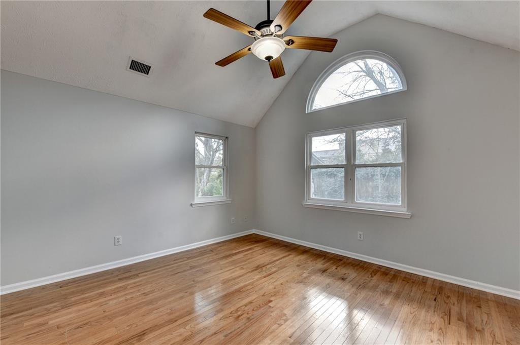 1112 Ashbury Drive Decatur, GA 30030 - Photo 50 of 64 an empty room with wooden floor chandelier fan and windows