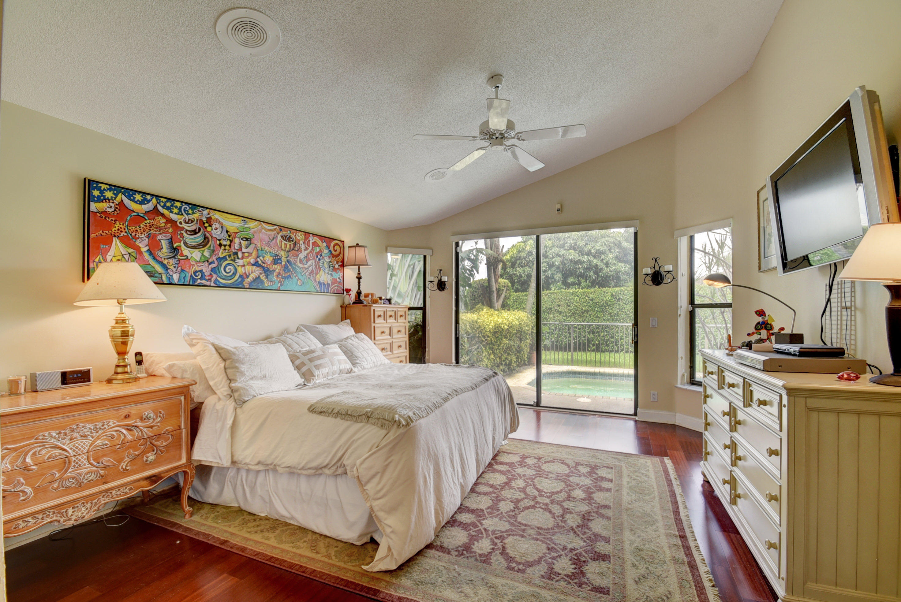 4426 Northwest 29th Way Boca Raton, FL 33434 - Photo 10 of 23 a bedroom with a large bed and a flat tv screen on dresser