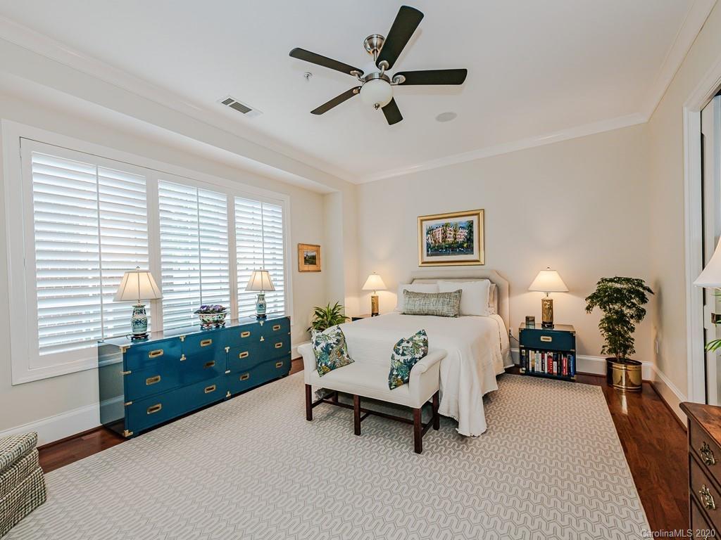 2223 Croydon Road, Unit 204 Charlotte, NC 28207 - Photo 16 of 27 a spacious bedroom with a bed and a chandelier