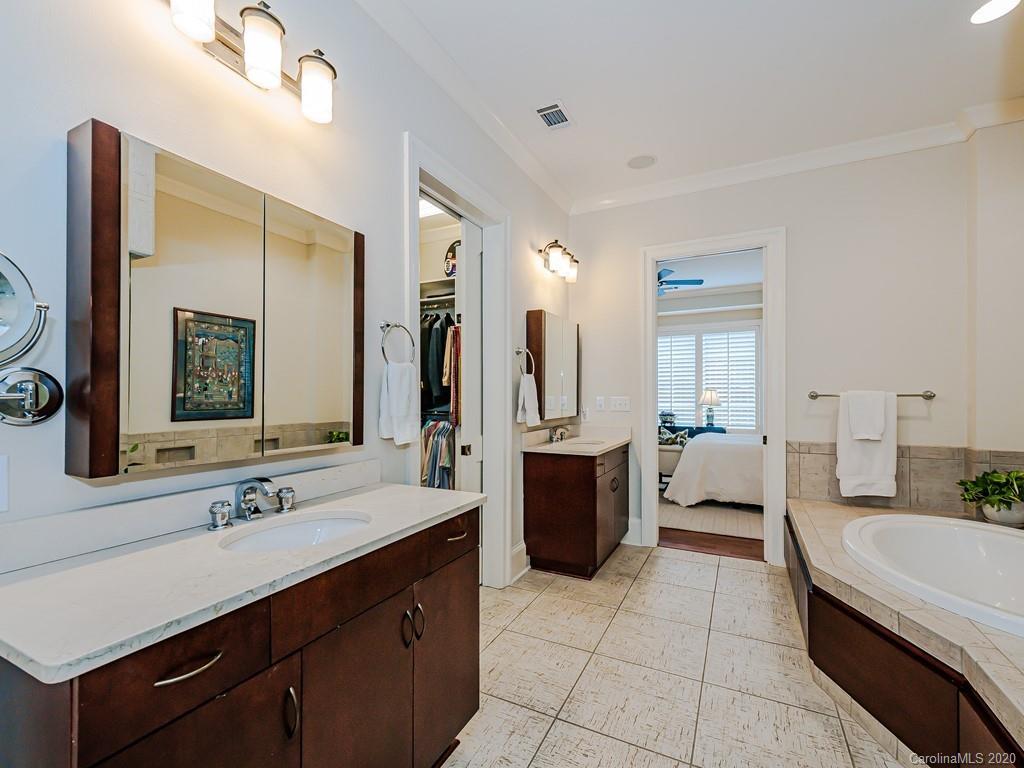 2223 Croydon Road, Unit 204 Charlotte, NC 28207 - Photo 19 of 27 a spacious bathroom with a double vanity sink a mirror and a bathtub