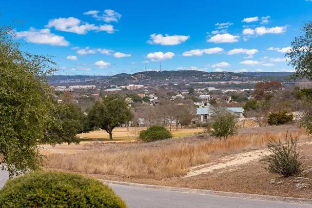 an aerial view of residential houses with outdoor space and parking