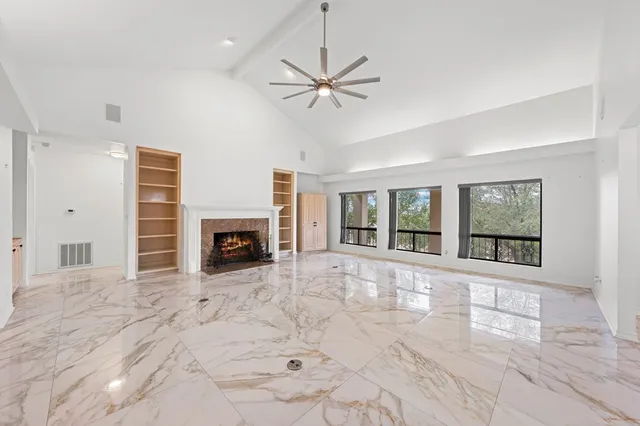 a view of a livingroom with a ceiling fan and window