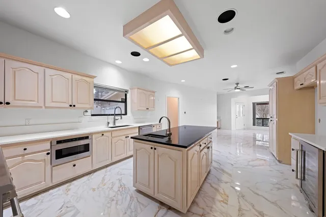 a kitchen with a sink a counter top space stainless steel appliances and cabinets