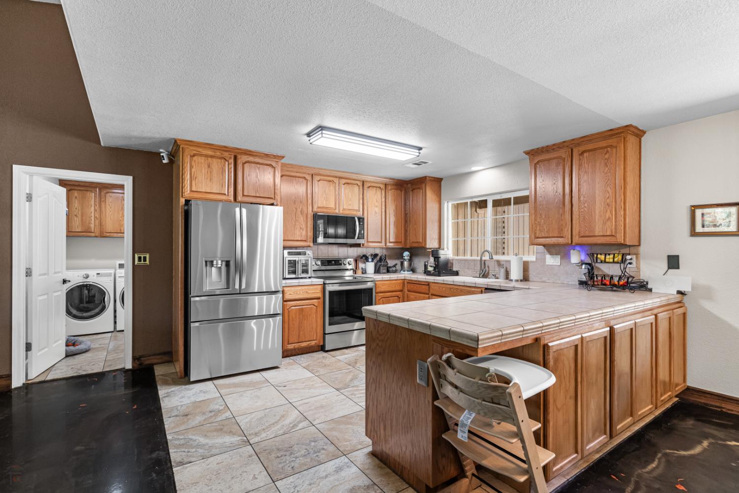2384 Choctaw Road Copperopolis, CA 95228 - Photo 17 of 53 a kitchen with a refrigerator a microwave a sink and cabinets
