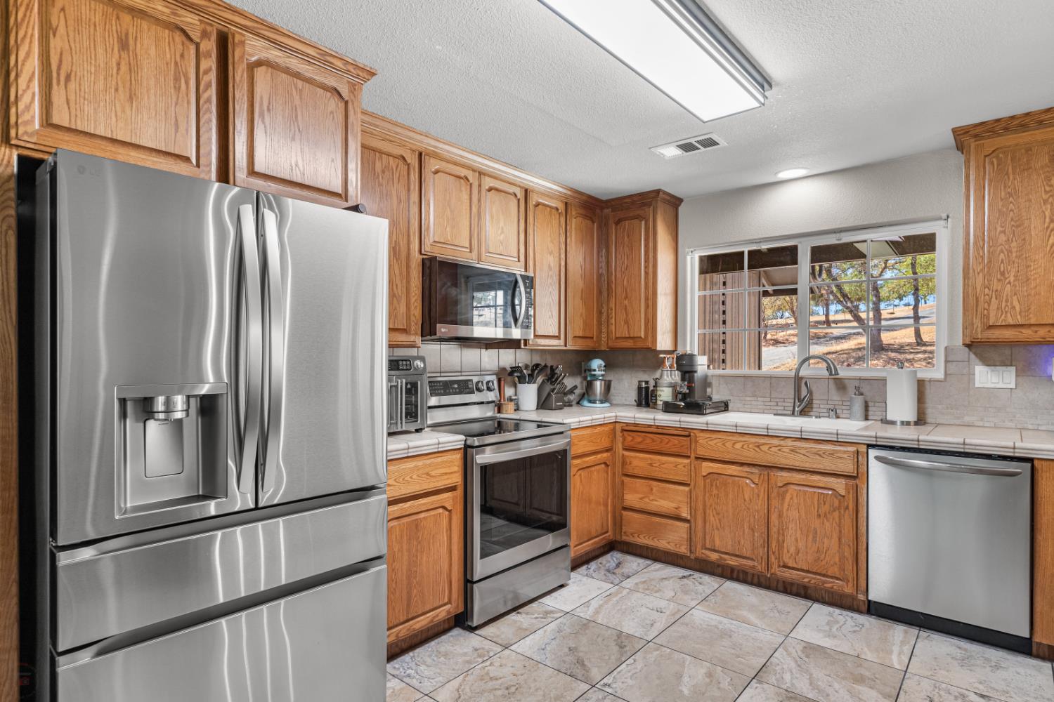 2384 Choctaw Road Copperopolis, CA 95228 - Photo 19 of 53 a kitchen with stainless steel appliances granite countertop a refrigerator sink and cabinets
