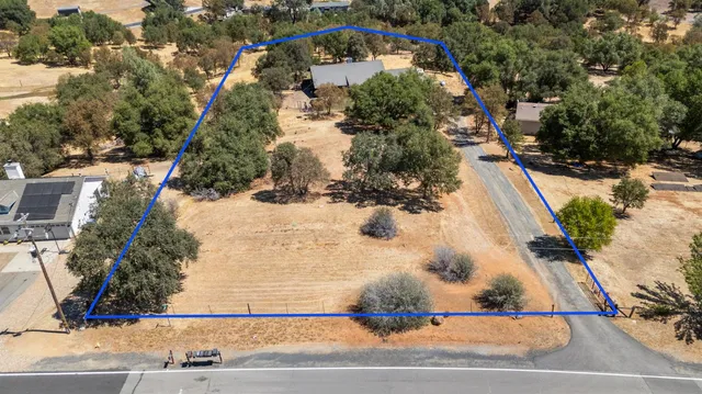 an aerial view of a house with a yard and mountain view in back