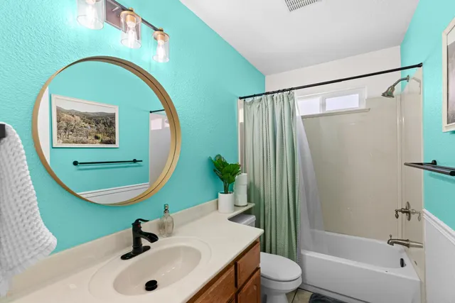 a bedroom with a bed a large window with table and chairs