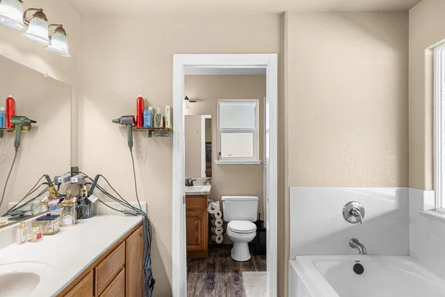 a bathroom with a sink double vanity granite and a toilet