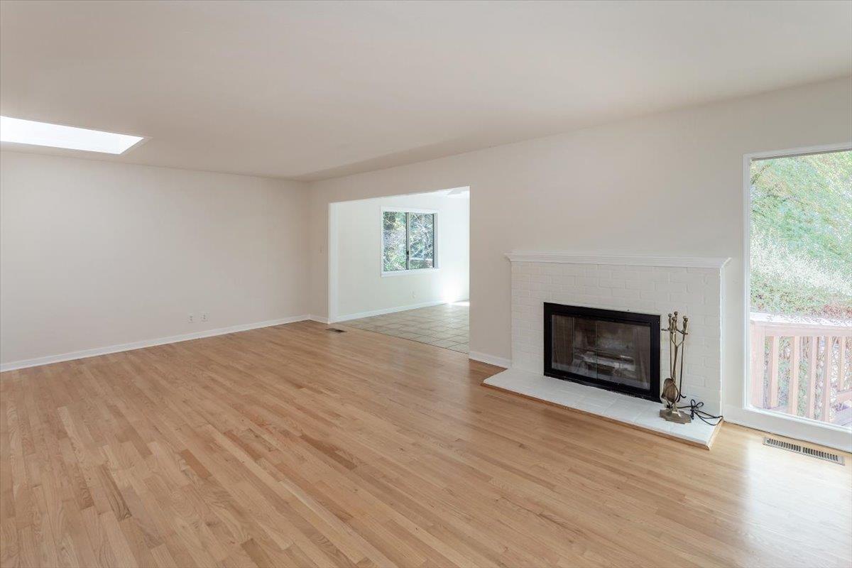 21685 Woolaroc Drive Los Gatos, CA 95033 - Photo 6 of 28 an empty room with wooden floor fire place and windows