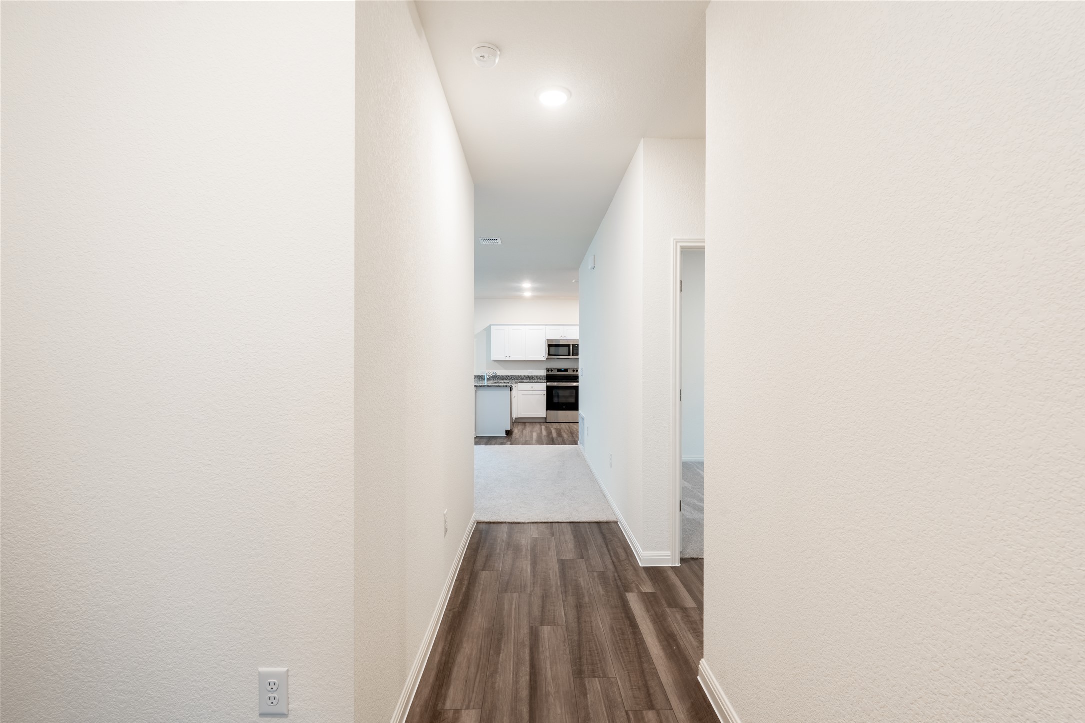 144 Mullen Way Taylor, TX 76574 - Photo 15 of 26 a view of a hallway with wooden floor and staircase