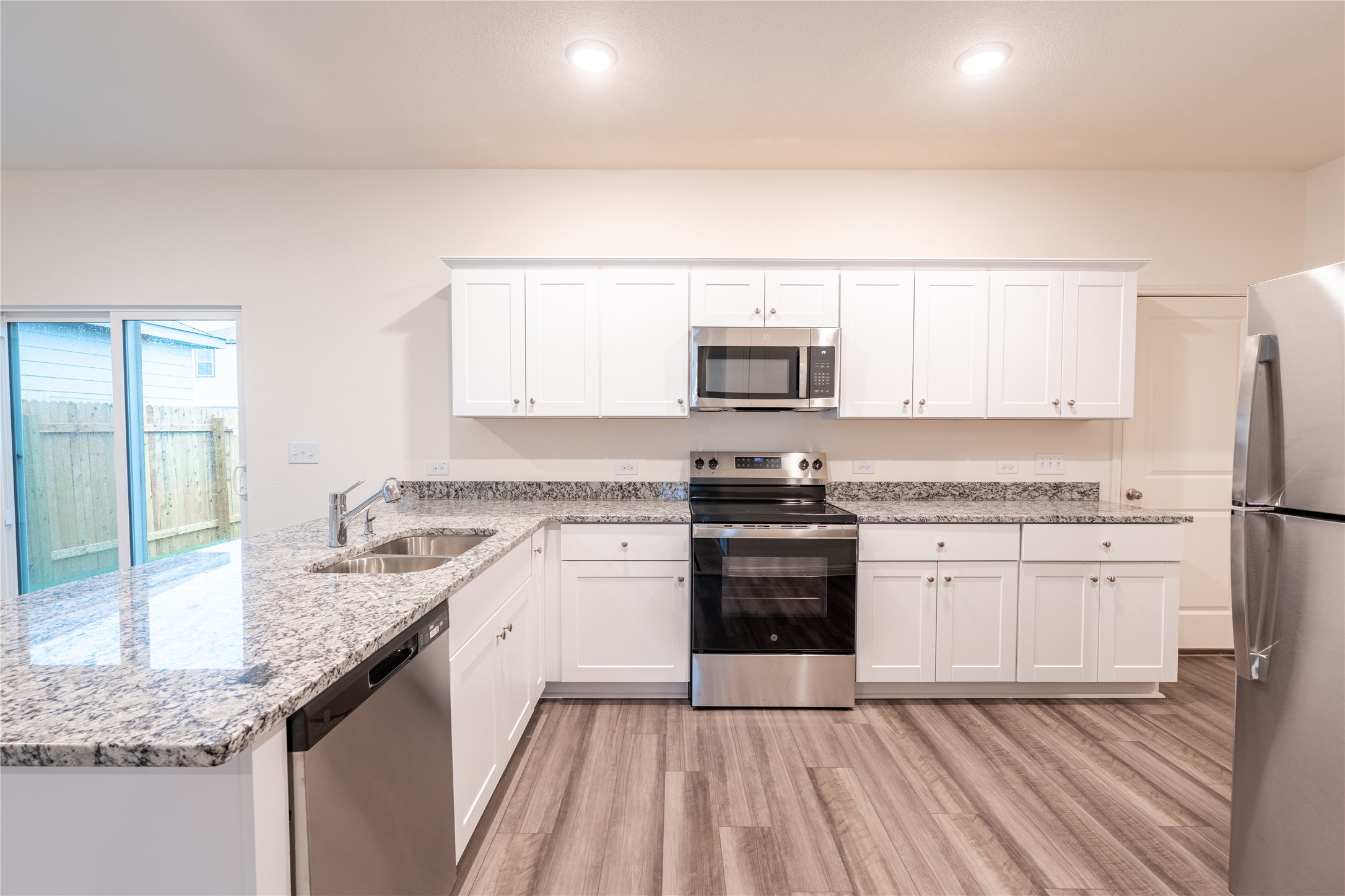 144 Mullen Way Taylor, TX 76574 - Photo 2 of 26 a kitchen with stainless steel appliances granite countertop a stove a sink and a refrigerator