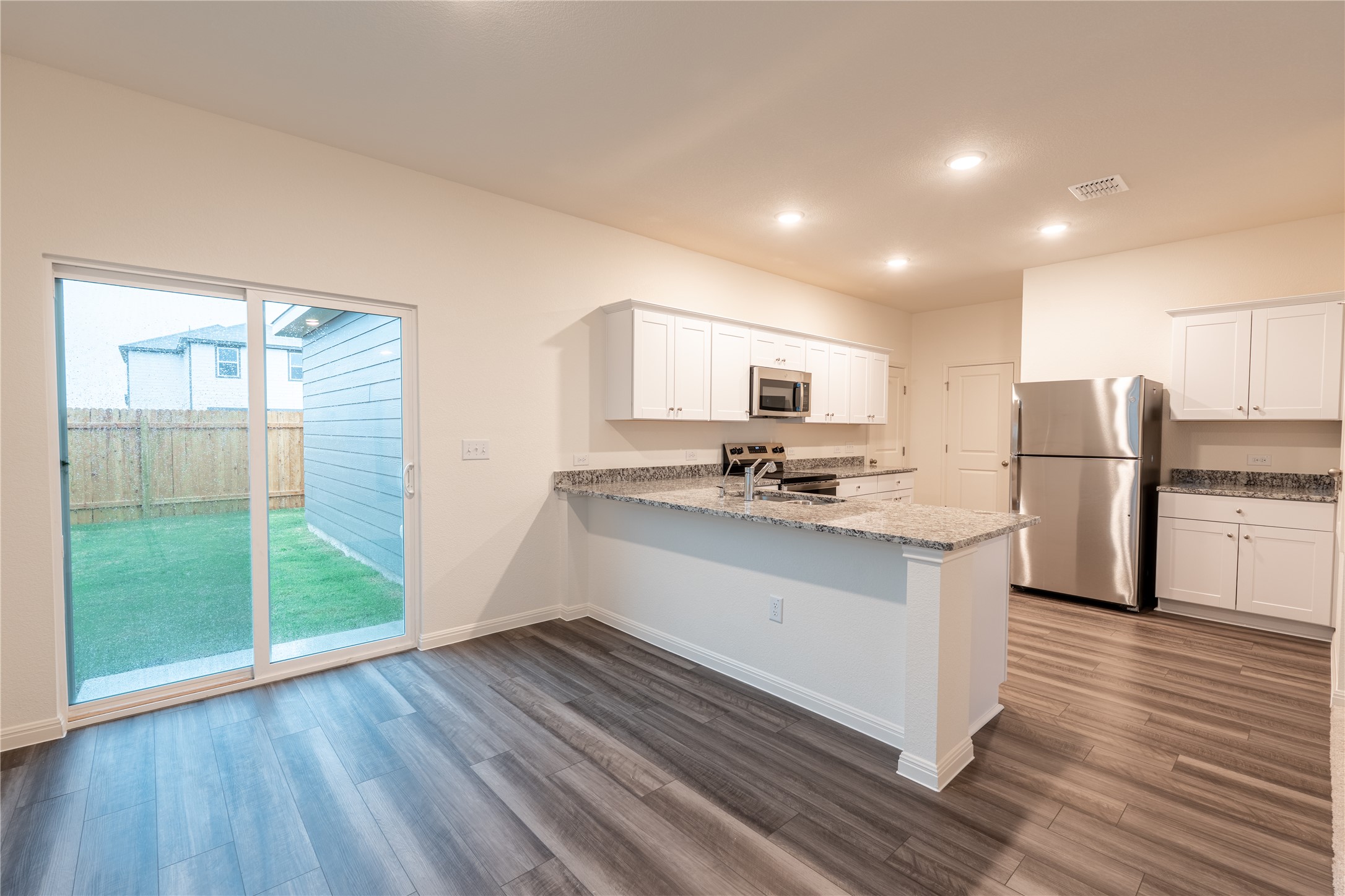 144 Mullen Way Taylor, TX 76574 - Photo 6 of 26 a kitchen with stainless steel appliances a refrigerator and a stove top oven