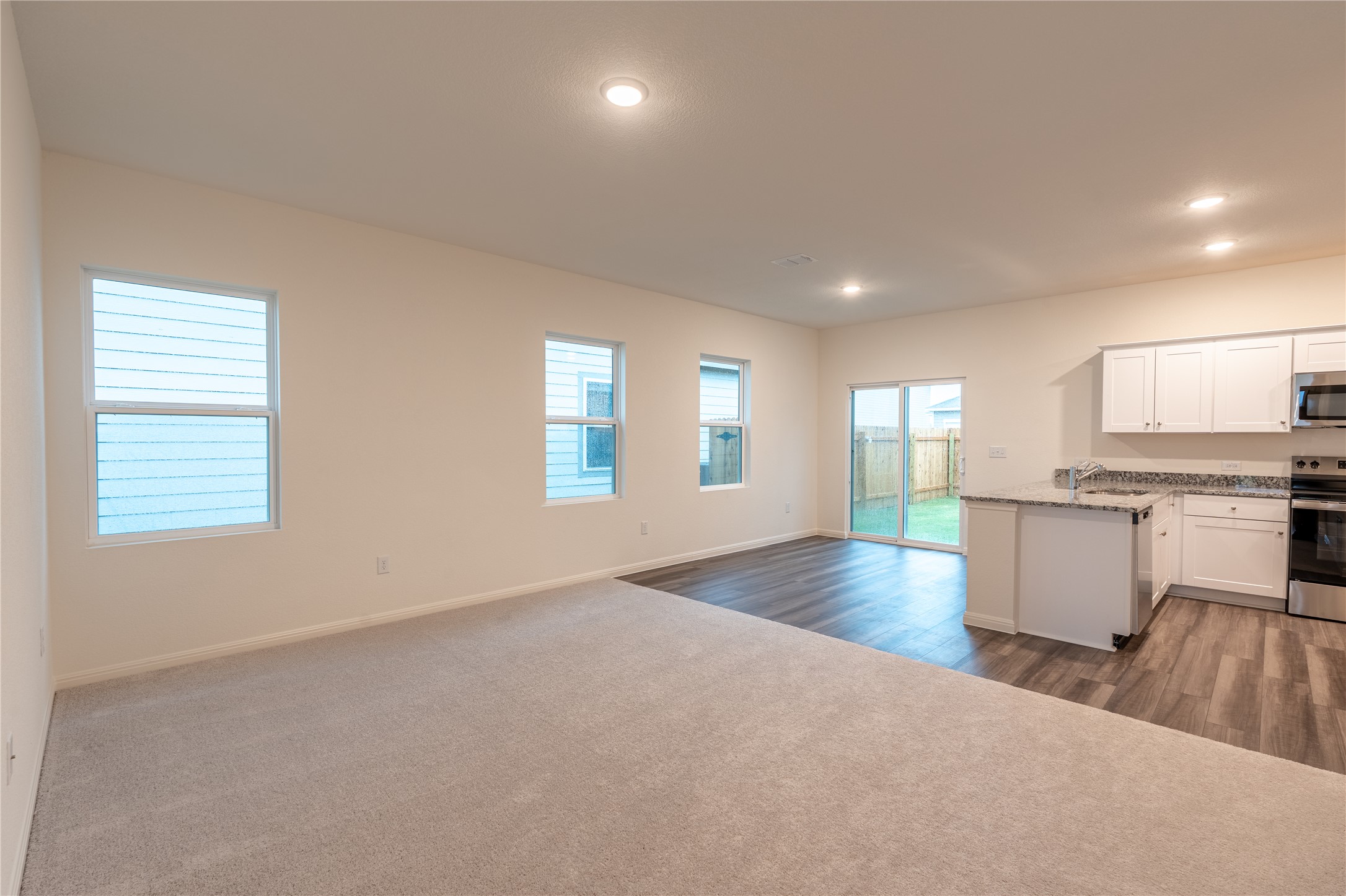 144 Mullen Way Taylor, TX 76574 - Photo 7 of 26 a view of empty room with kitchen and window