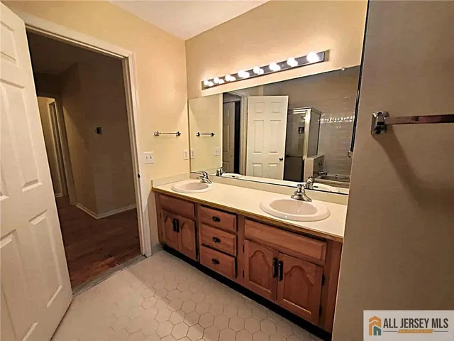 a spacious bathroom with a double vanity sink and a mirror
