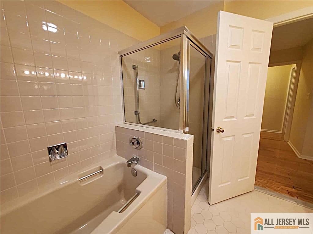 38 Rutland Lane, Unit 38A Monroe Township, NJ 08831 - Photo 12 of 19 a bathroom with a tub a sink and a large mirror
