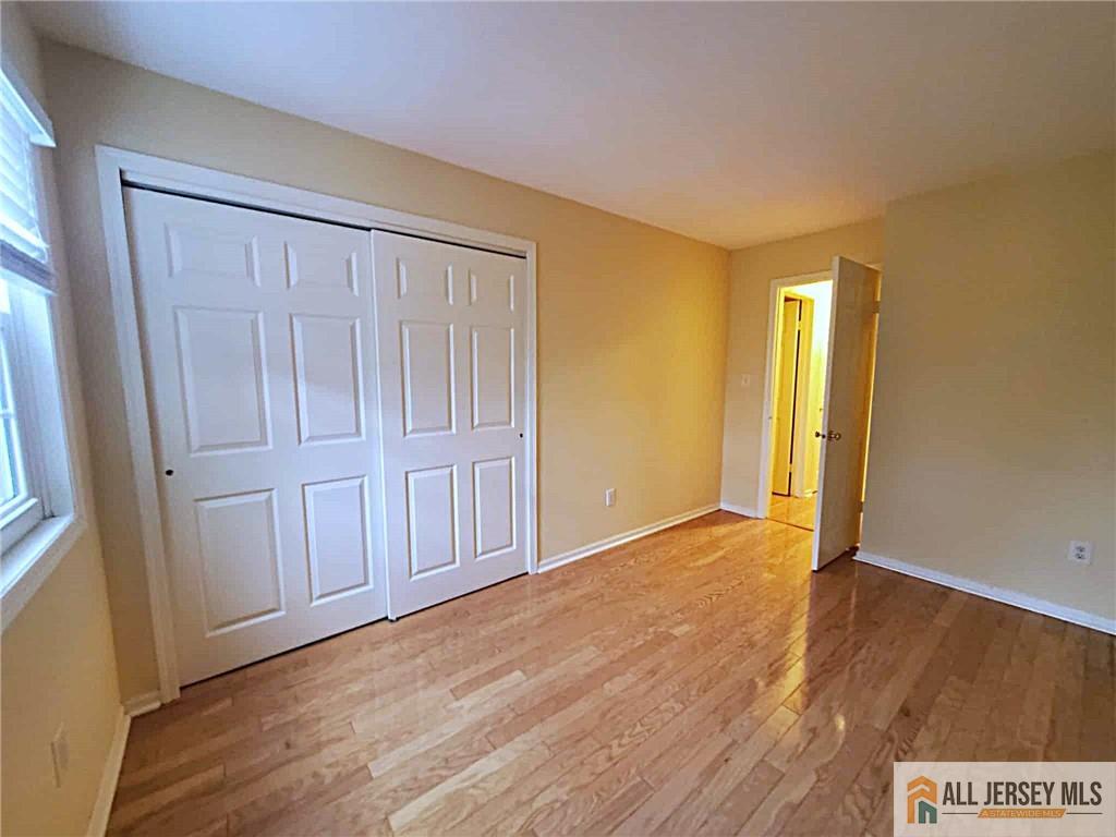38 Rutland Lane, Unit 38A Monroe Township, NJ 08831 - Photo 13 of 19 an empty room with wooden floor and windows