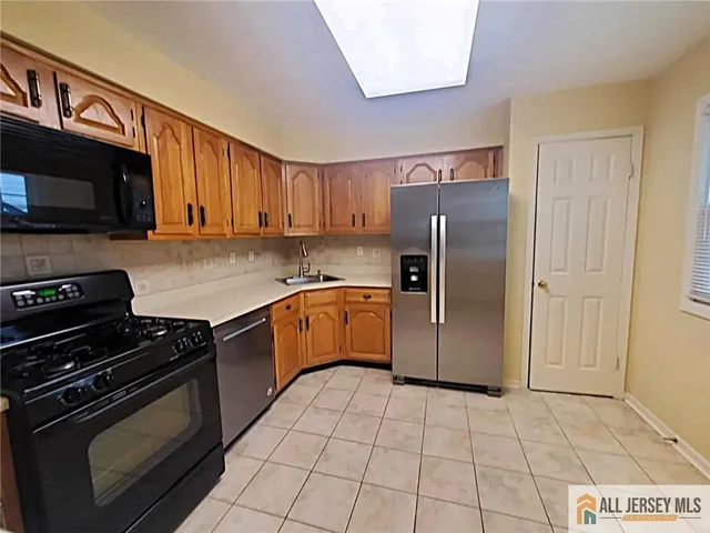 a kitchen with a refrigerator sink and cabinets