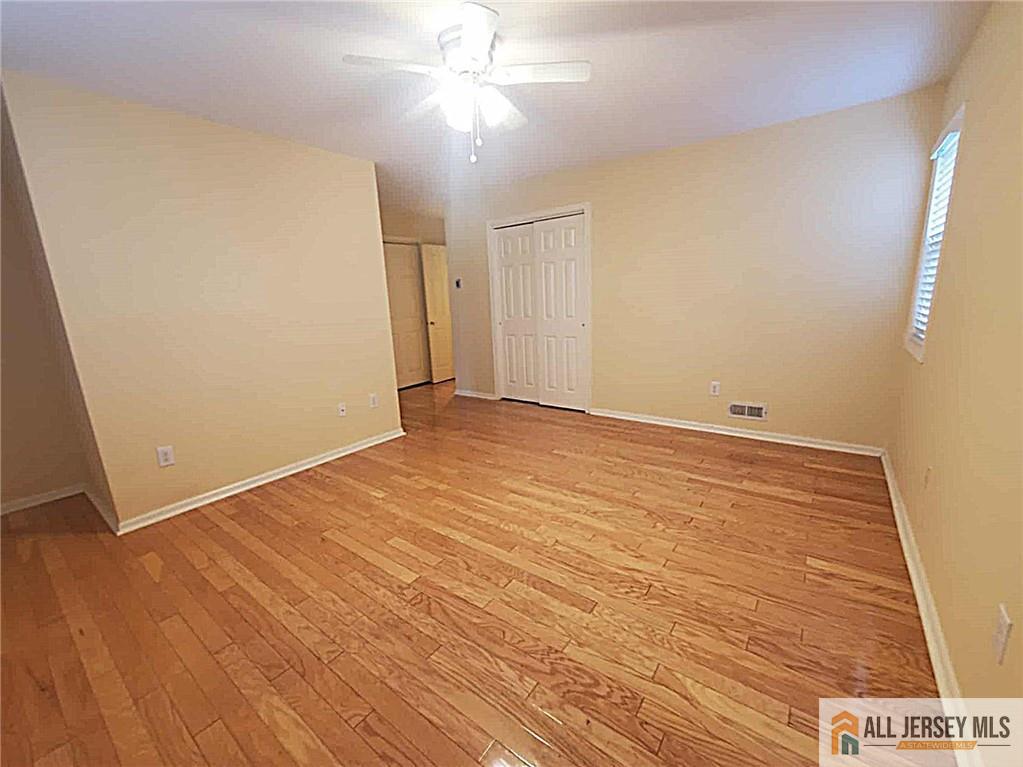 38 Rutland Lane, Unit 38A Monroe Township, NJ 08831 - Photo 9 of 19 an empty room with wooden floor and fan