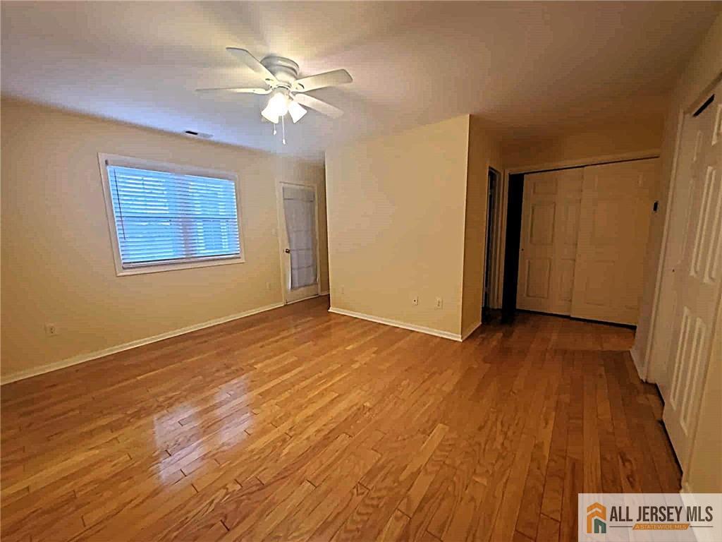38 Rutland Lane, Unit 38A Monroe Township, NJ 08831 - Photo 10 of 19 a view of an empty room with wooden floor and a ceiling fan