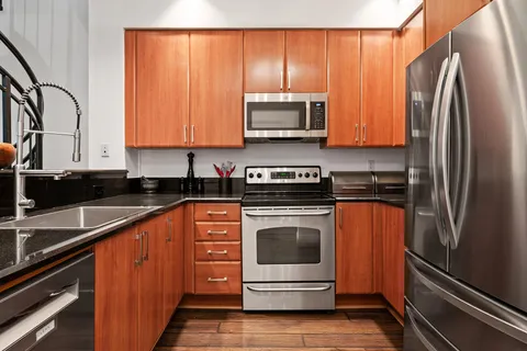a kitchen with stainless steel appliances granite countertop a refrigerator stove and sink