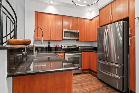a kitchen with granite countertop a refrigerator stove and microwave