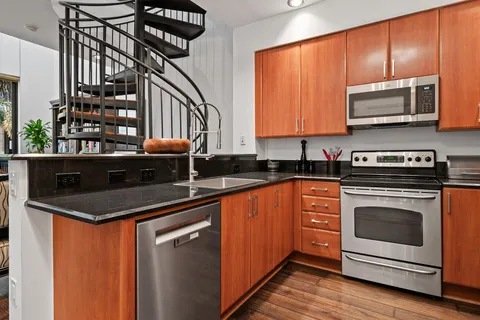 a kitchen with stainless steel appliances a stove a sink and a microwave