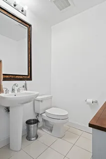 a bathroom with a toilet a sink and mirror