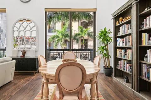 a dining room with furniture a book shelves and wooden floor